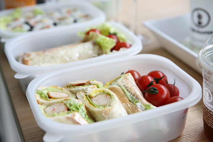 Representative Image: two white plastic containers with sandwich and tomatoes.