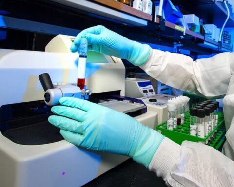 Representative Image: Scientist in a lab coat and gloves operating a piece of laboratory equipment. Photo Source: Rawpixel