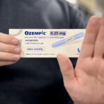 A person holding a box of Ozempic (semaglutide) 0.25 mg, which is a medication for subcutaneous use in a pre-filled pen. The packaging states that it is used once weekly and includes one pen and four disposable needles (4 doses). Photo Source: Flickr- Chemist4U (CC BY-SA 2.0)