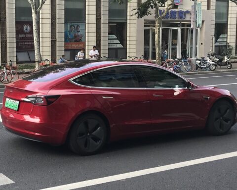 Representative Image. A red Tesla Model 3 electric vehicle driving down a bustling urban street. Photo Source - Jengtingchen (CC BY-SA 4.0)