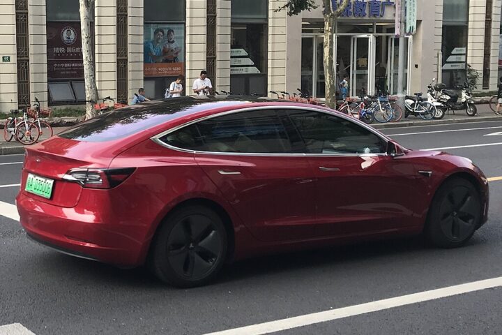 Representative Image. A red Tesla Model 3 electric vehicle driving down a bustling urban street. Photo Source - Jengtingchen (CC BY-SA 4.0)