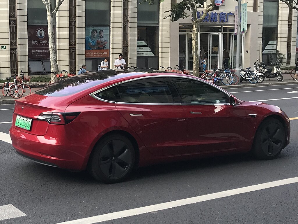 Representative Image. A red Tesla Model 3 electric vehicle driving down a bustling urban street. Photo Source - Jengtingchen (CC BY-SA 4.0)